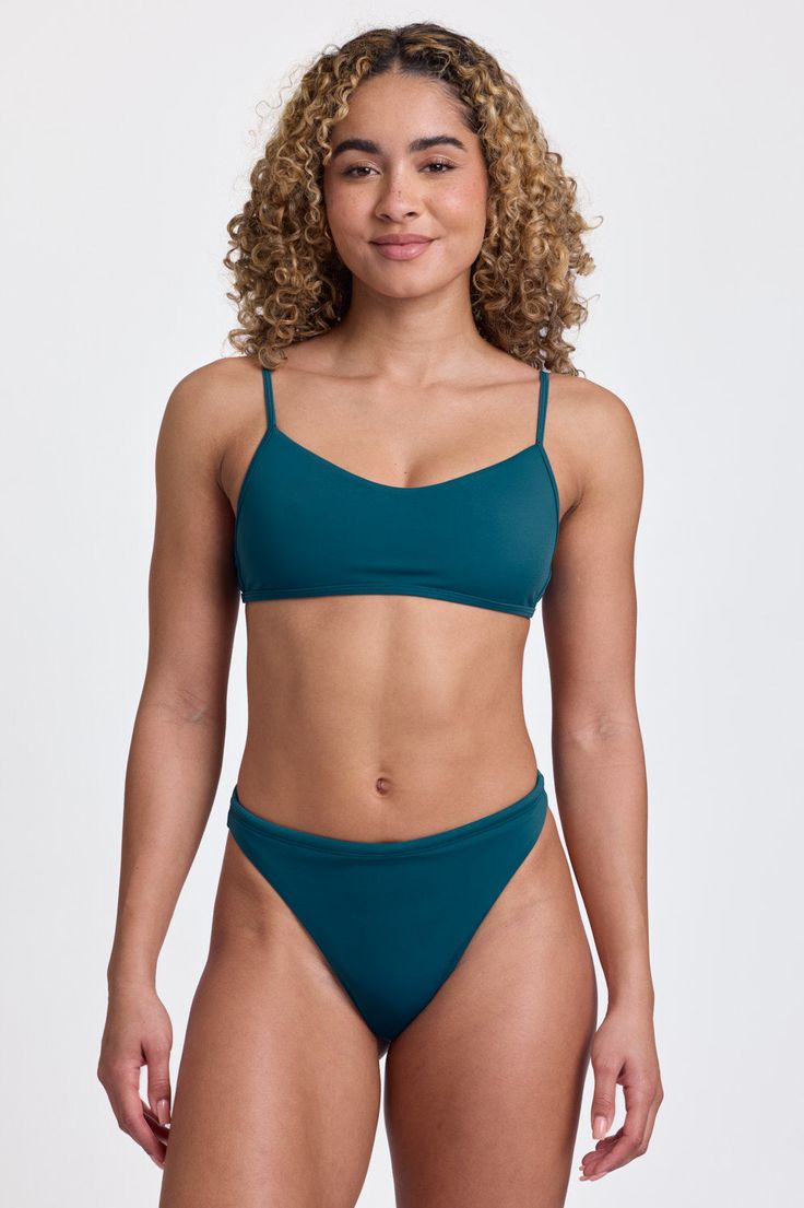 Ava by Jolyn in Lake - Sunset Park Resort swimwear, teal bikini on model, white backdrop