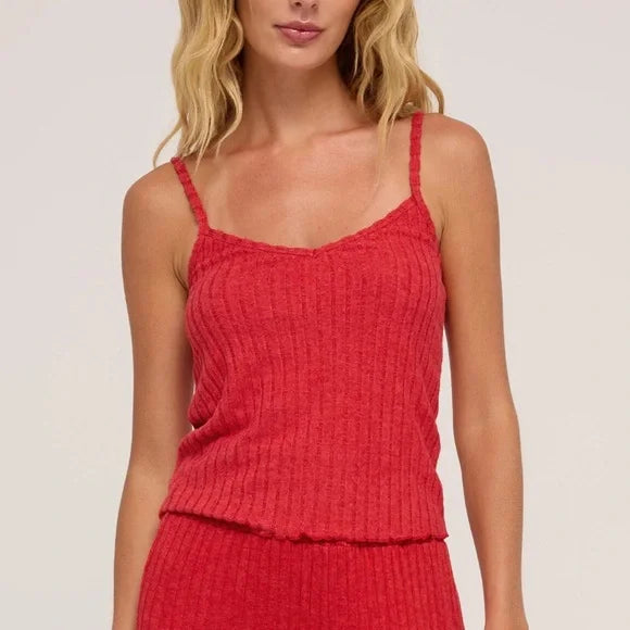 Woman wearing a red textured top against a plain background